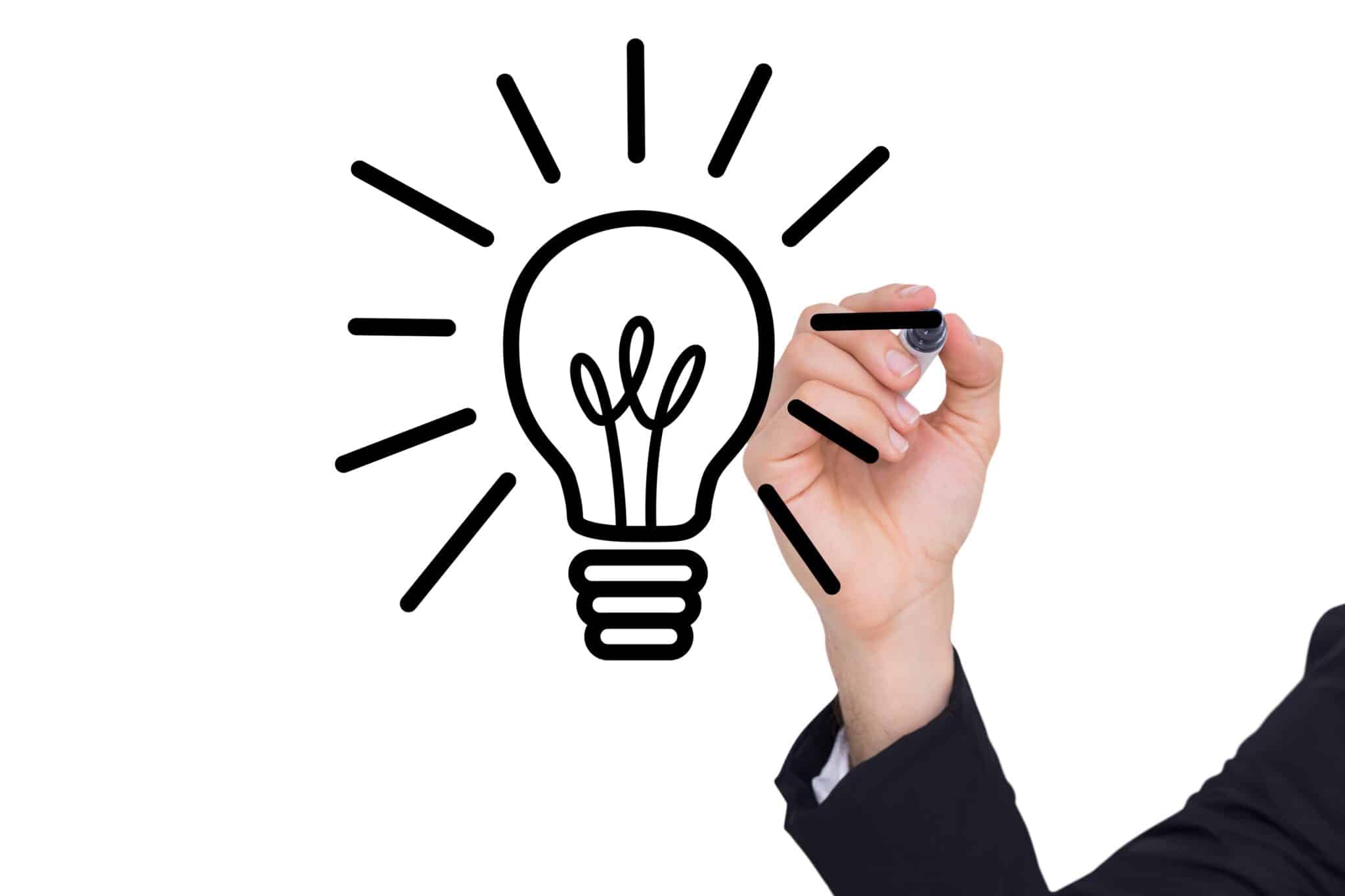 Composite of image of a hand drawing a light bulb on a board Composite of image of a hand drawing a light bulb on a board