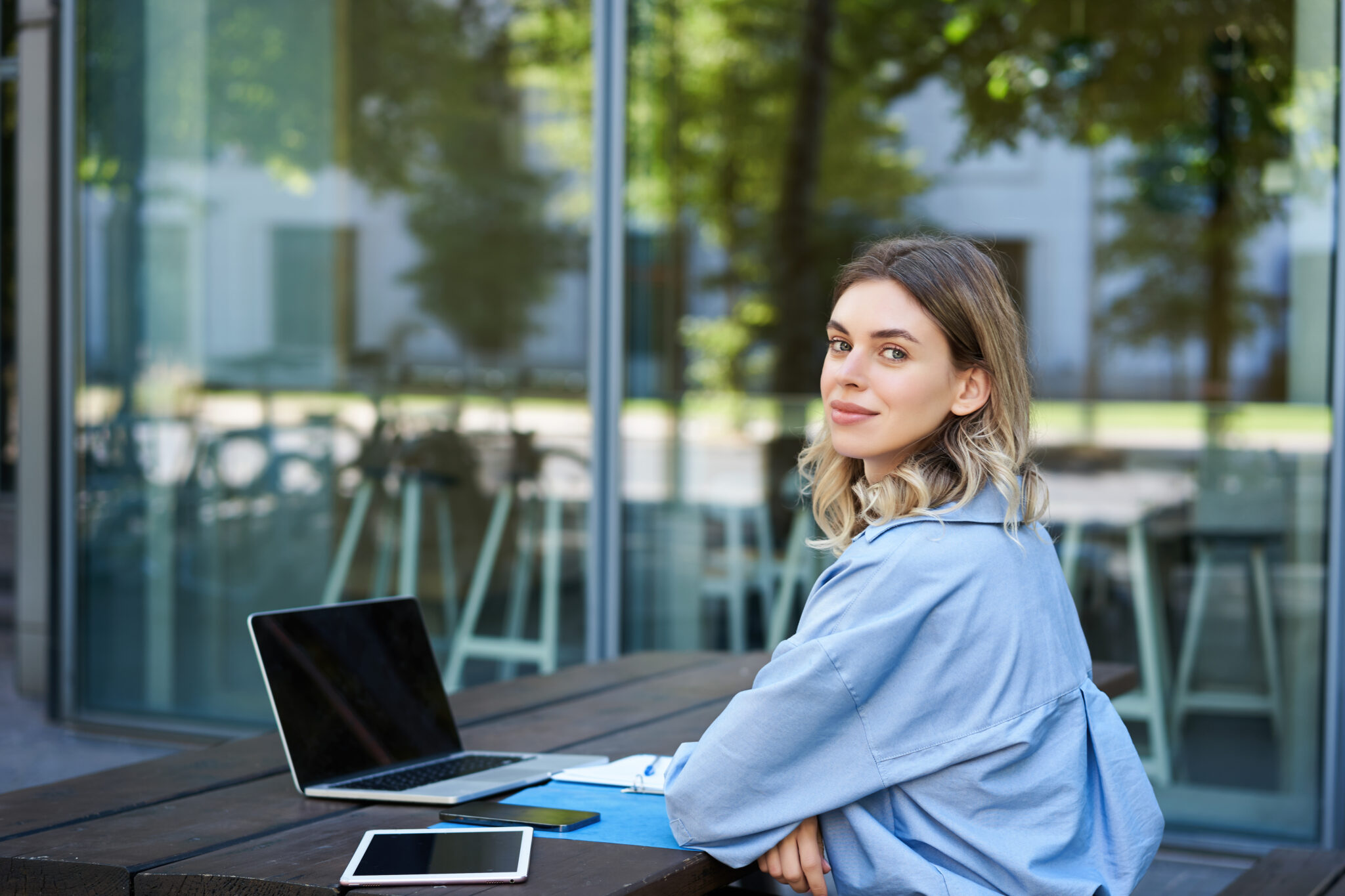 Portrait of young businesswoman working, using laptop while sitting outdoors. Corporate woman on video chat meeting.
